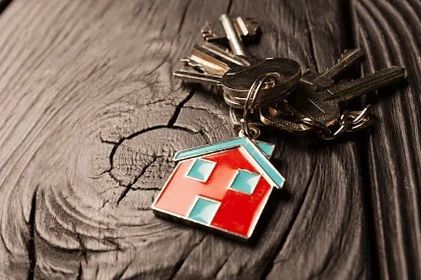 A freshly cut key with a red house-shaped keychain